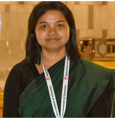 Woman wearing a green sari and a lanyard labeled 