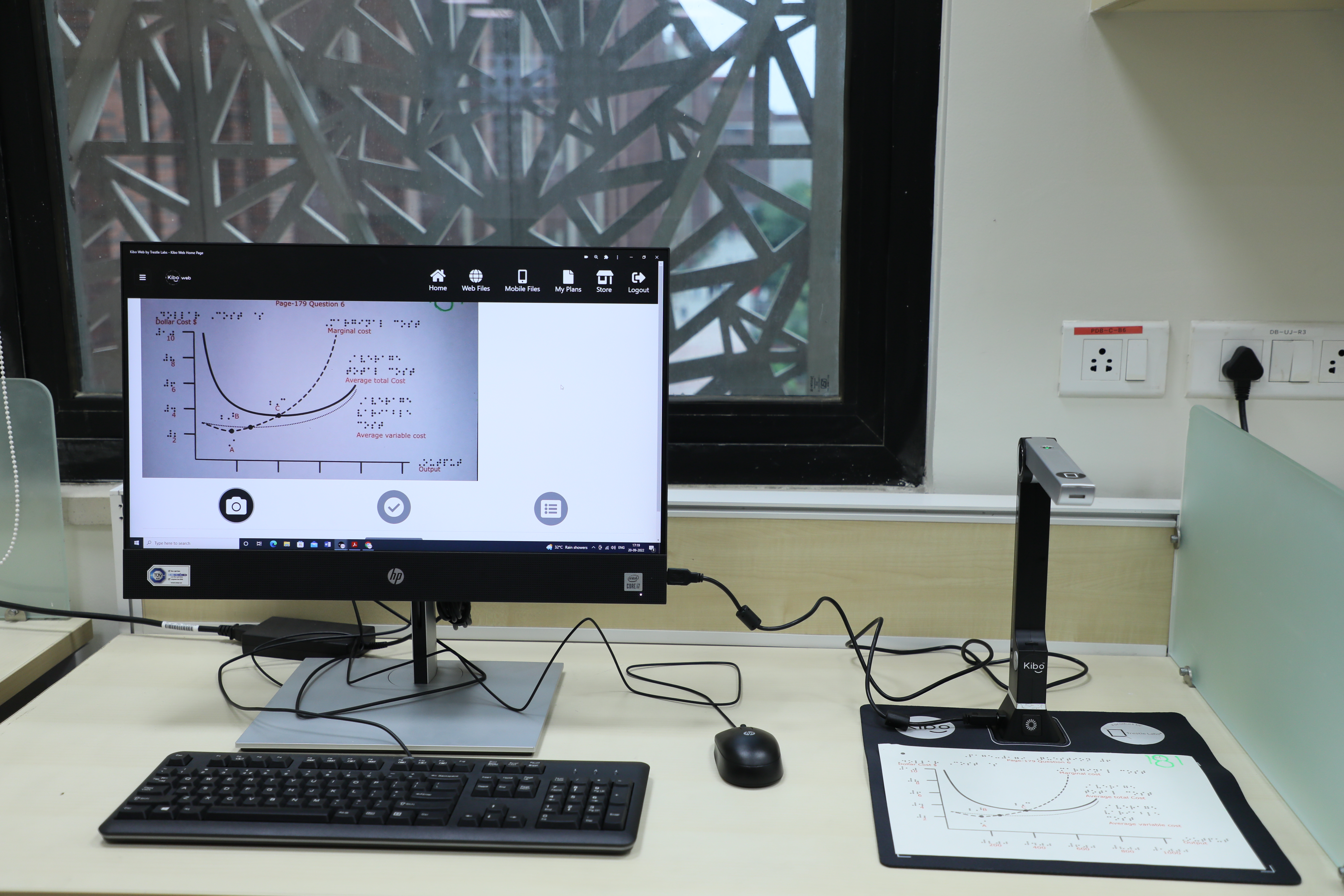 A close-up shot of Kibo XS device connected to a desktop, conductin OCR of a graph