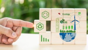 Wooden blocks with eco-friendly icons, including recycling, wind turbine, and Earth graphics.