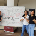 Four people stand in front of a whiteboard with "Internship Cell Townhall" written on it, smiling.