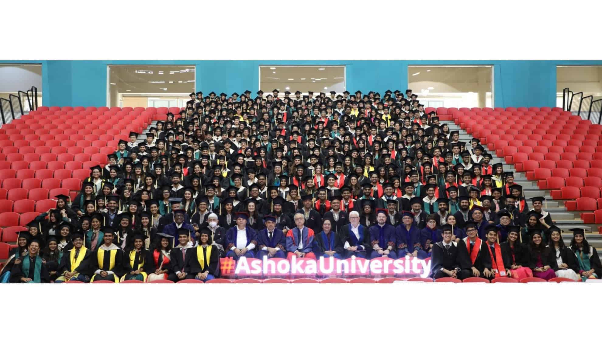 Graduates in caps and gowns seated in rows, with faculty in front and "#AshokaUniversity" sign.