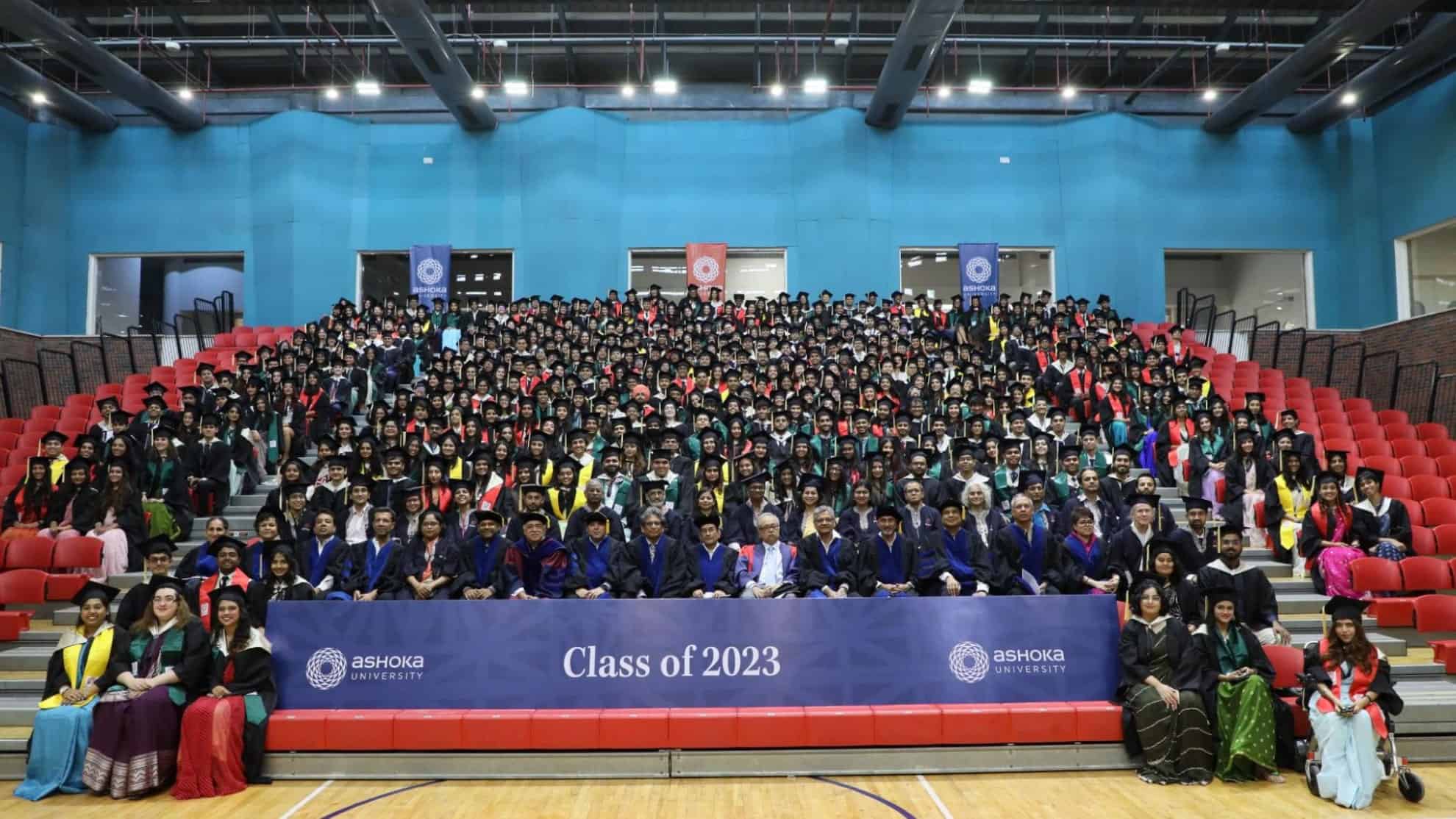 Graduating students and faculty in ceremonial attire seated in rows, banner reads "Class of 2023".
