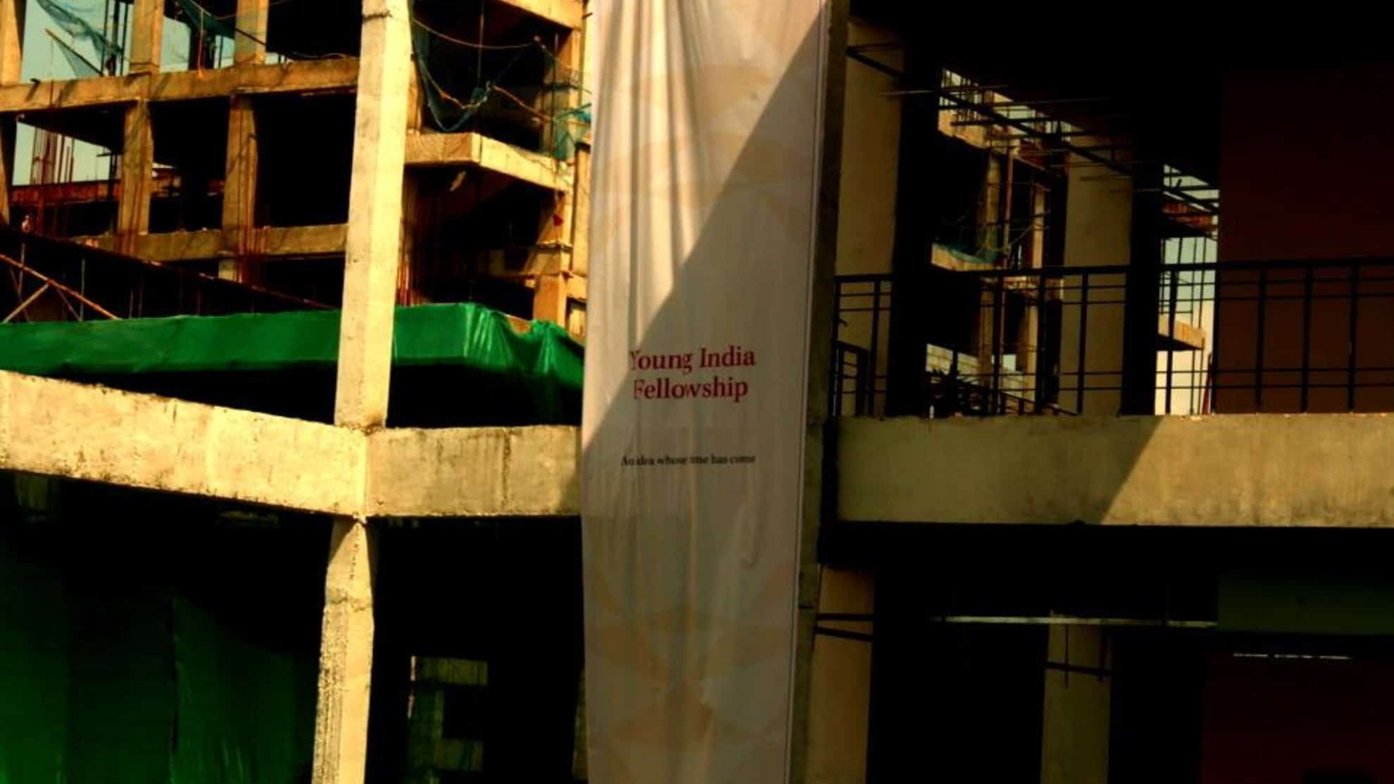 Construction site with a banner reading "Young India Fellowship" and "An idea whose time has come".
