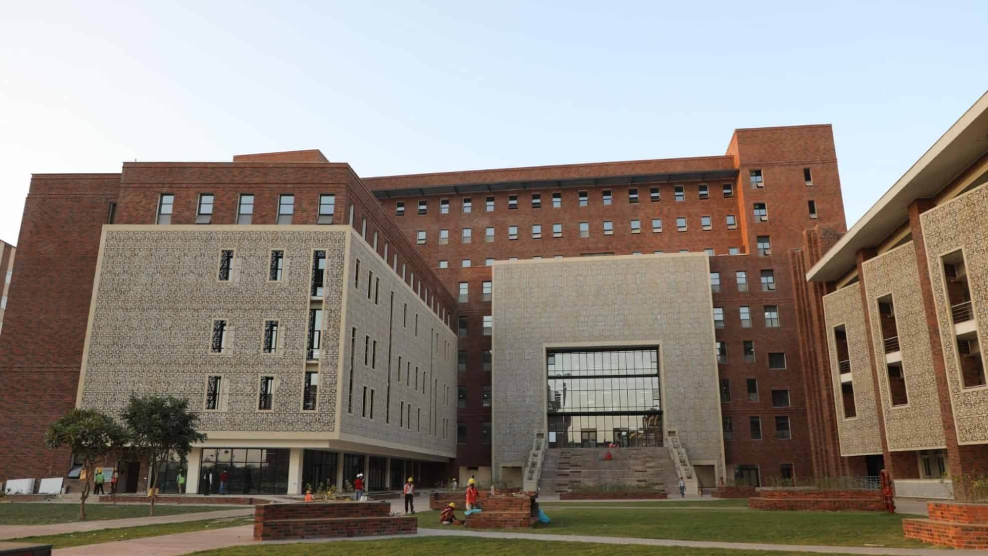 Brick and patterned facade buildings with a central staircase, open courtyard, and scattered people.