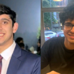 Two smiling young men, one in a suit and tie, the other in glasses and a black shirt indoors.