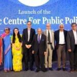 Group of people standing on stage at the launch of the Isaac Centre